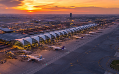 Vista aérea del aeropuerto internacional Suvarnabhumi de Bangkok al atardecer, gran terminal moderna con aviones en puertas de embarque