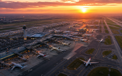 Vista aérea de un aeropuerto europeo concurrido con aviones en pista al atardecer