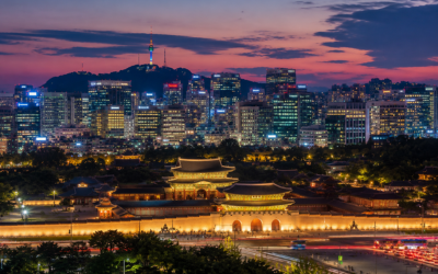 Vista panorámica del skyline de Seúl al anochecer con el palacio Gyeongbokgung iluminado en primer plano y los rascacielos modernos al fondo